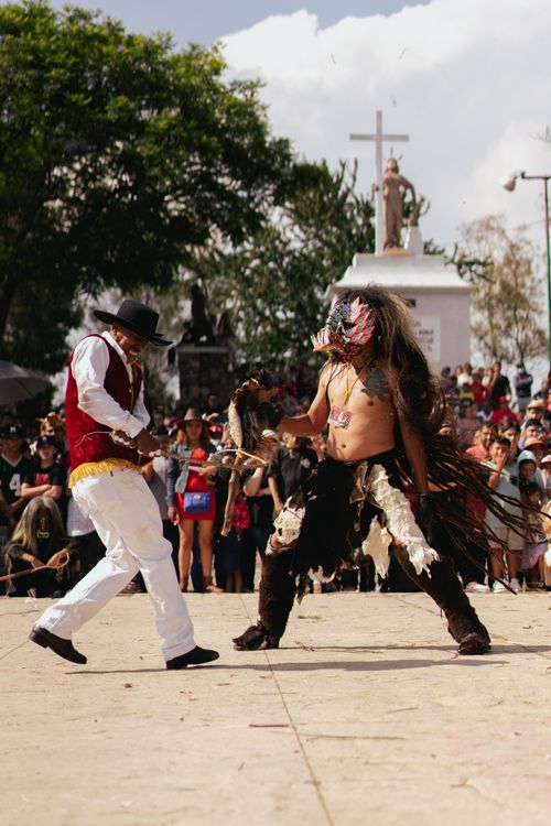 Free Traditional Mexican dancers performing at a cultural festival with a lively crowd. Stock Photo