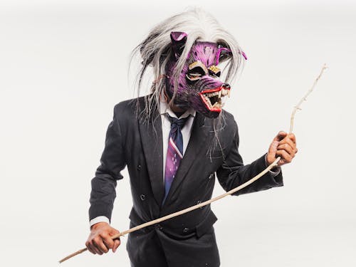 Studio Shot of a Man in a Suit and Purple Mask