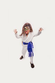A child wearing a colorful Mexican mask and costume on a white background.
