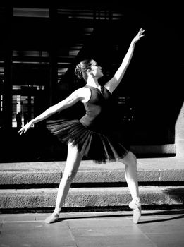 A captivating monochrome image of a ballet dancer striking a pose on city steps.