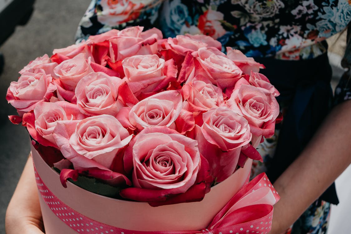 Лицо, держащее букет розовых роз