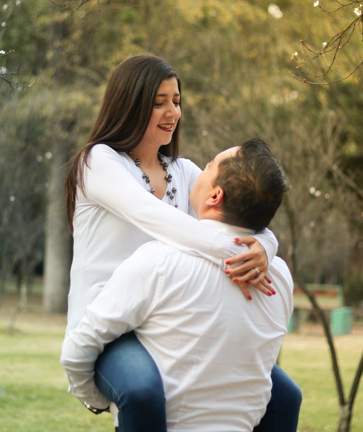 Man Holding Woman In Arms In Park