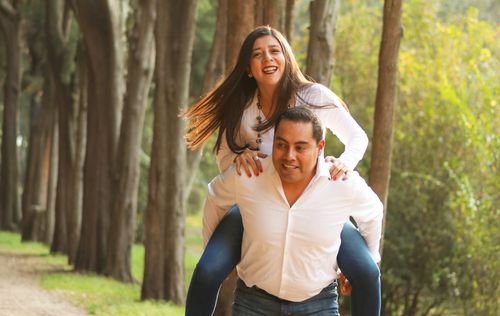 Free Happy couple enjoying a piggyback ride outdoors, showcasing love and joy. Stock Photo