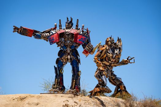 Metal sculptures resembling transformers under a bright blue sky in Aguanga, CA.