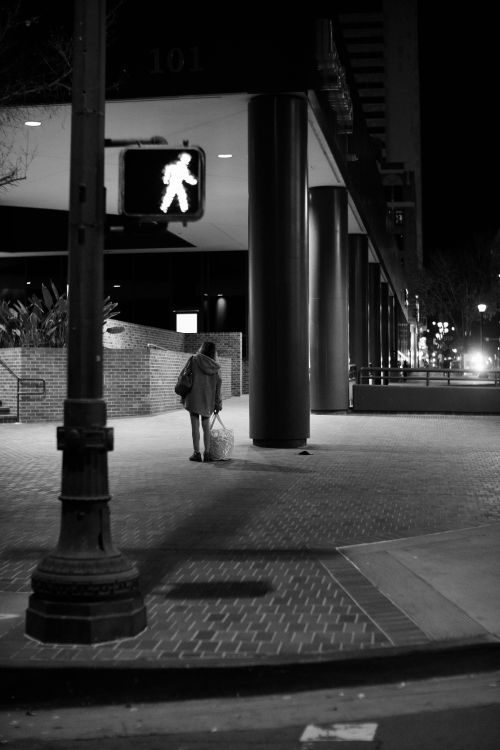 Free Black and white photo of a pedestrian walking at night in downtown San Diego, CA. Stock Photo