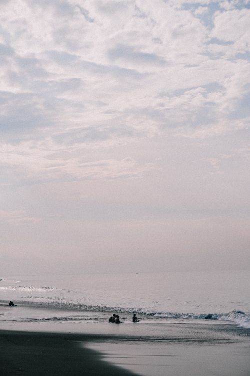 Free A peaceful beach scene at dusk, featuring gentle waves and a serene horizon. Stock Photo
