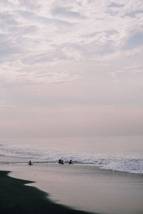Free Serene seascape with soft waves and a cloudy sky, perfect for a tranquil evening. Stock Photo