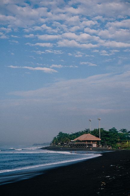 Beautiful black sand beach with a tranquil shore and scenic landscape, perfect for a serene getaway.
