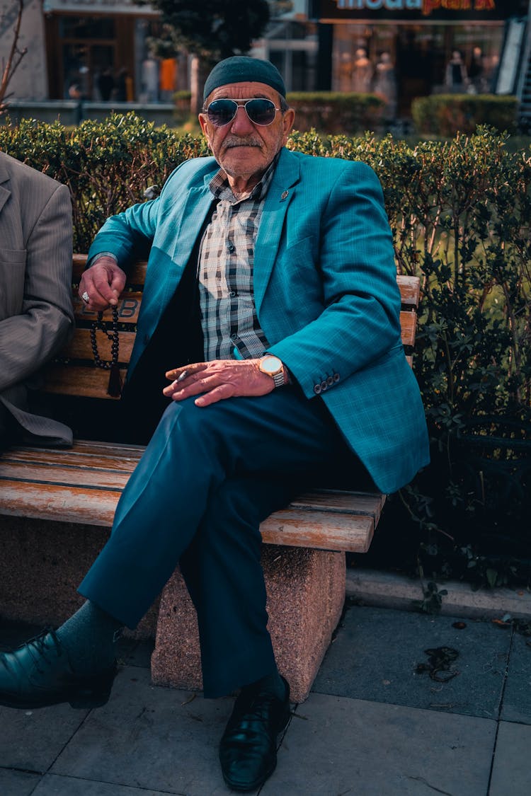 Elderly Man In Suit Jacket Sitting On Bench