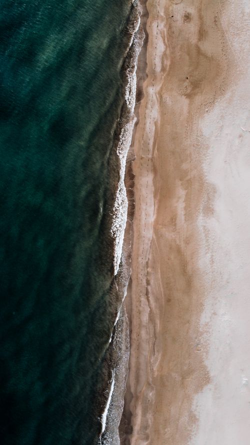 Free Stunning aerial view of Antalya's serene beach with crashing waves meeting the shoreline. Stock Photo