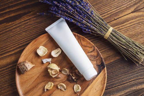 Tub of a Cosmetic Product, Lavender and Dried Petals on a Table