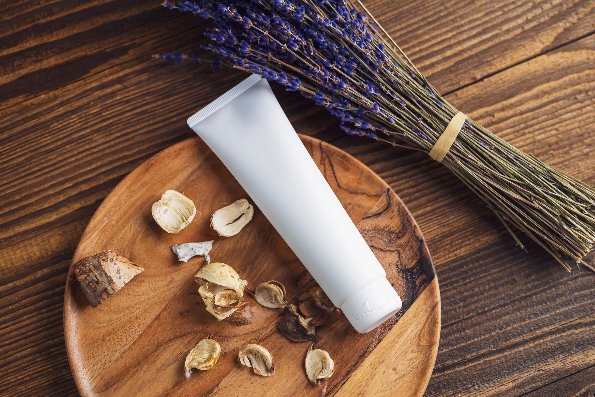 Tub of a Cosmetic Product, Lavender and Dried Petals on a Table