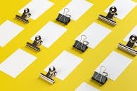 Pieces of Paper and Clips on a Yellow Background