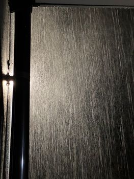 Close-up of a sleek black door with textured surface, captured in low lighting for dramatic effect.