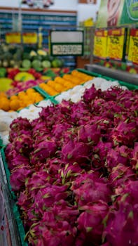 Vibrant dragon fruits and fresh produce in an Indonesian market setting.