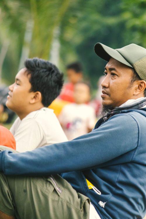 Free A father and son share a peaceful moment outdoors, highlighting family bonding. Stock Photo