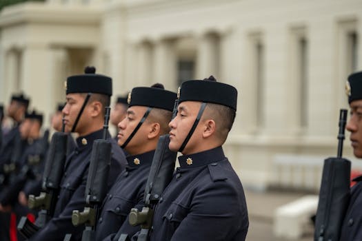 Gurkha soldiers in formal military uniforms standing in a line outdoors, displaying discipline and readiness.