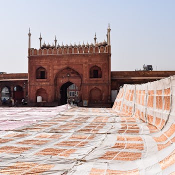 Sun-drenched courtyard of a mosque with colorful fabric drying in the open air.