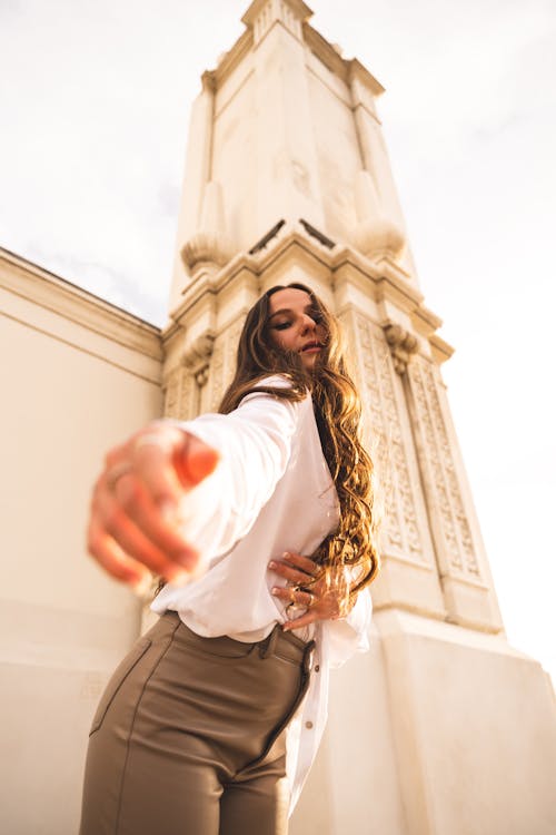 A Woman in White Long Sleeve Shirt and Brown Pants