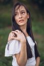 Woman with Long Hair in a White Blouse Looking over Shoulder