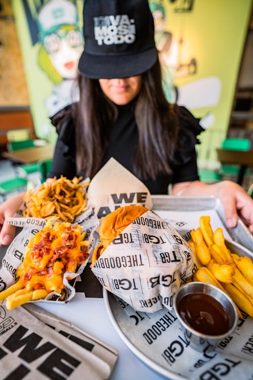 A Person Holding a Tray of Various Comfort Food