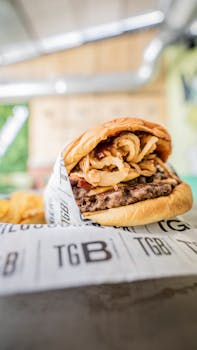 Juicy beef burger with crispy onions, perfect for food enthusiasts.