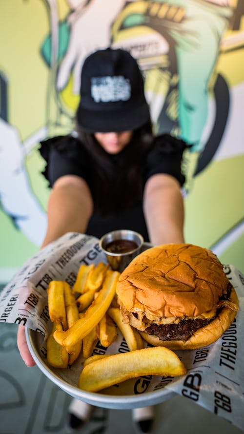A Person Holding a Burger on the Plate