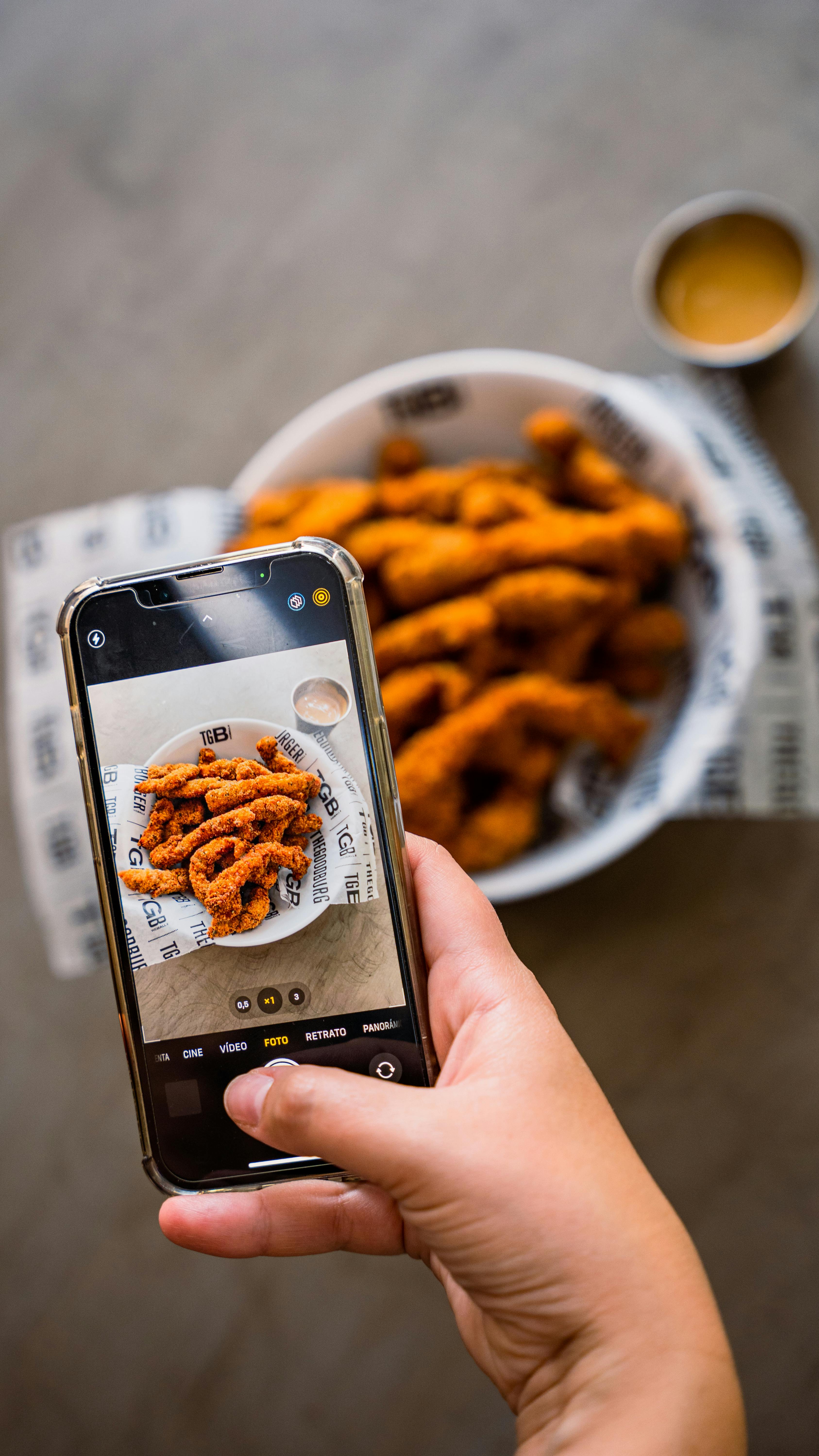 unrecognizable woman taking photo of food with mobile phone camera