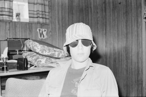 Grayscale Photo of Person Wearing Bucket Hat and Sunglasses 