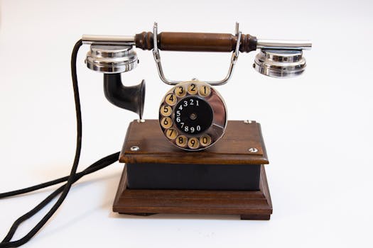 Classic vintage rotary dial telephone with wooden base and metal handle, showcasing retro design.