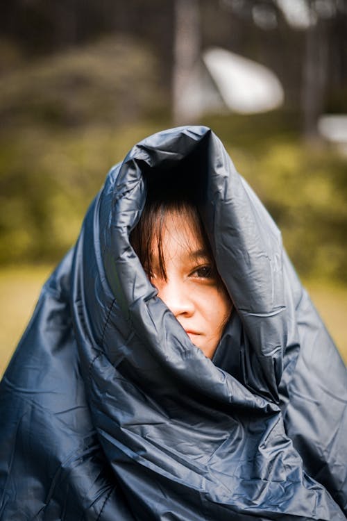 A Woman Covering her Face using a Leather Coat