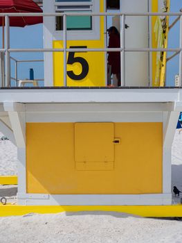 Vibrant lifeguard tower on a sunny beach, showcasing safety and leisure.