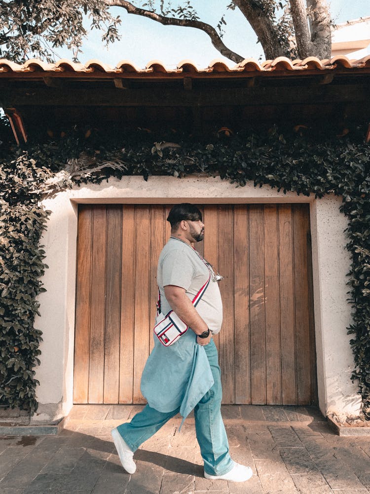 Man Walking Near Building With Garage