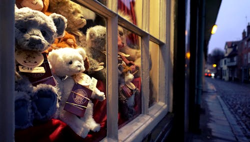 무료 유리창 근처에있는 모듬 된 색깔 곰 견면 벨벳 장난감 스톡 사진