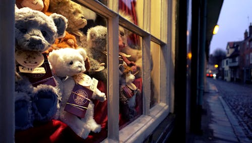 Assorted Color Bear Plush Toys Near Glass Window