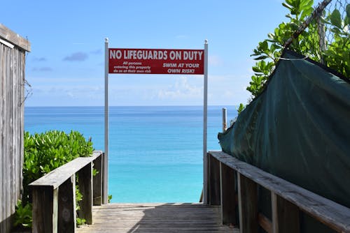 A No Lifeguards on Duty Sign at a Beach Entrance