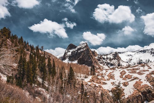 A Snow Covered Rocky Mountain Under the Cloudy Sky