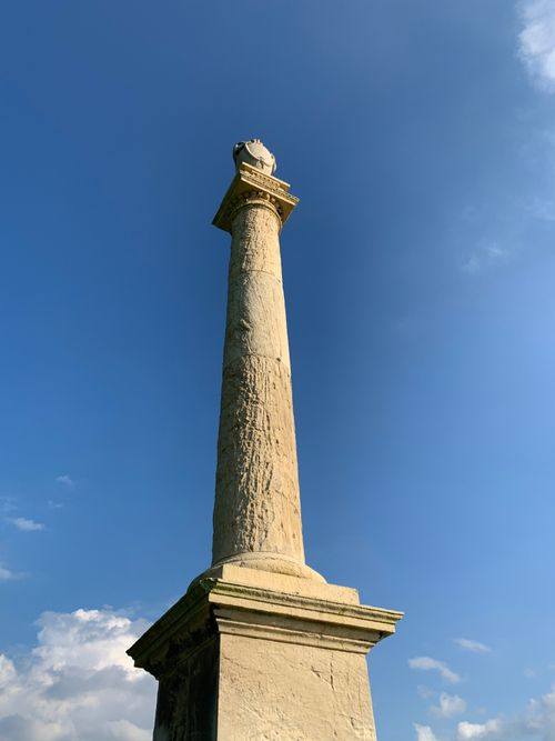 Free Impressive ancient stone column reaching skyward under clear blue skies. Stock Photo