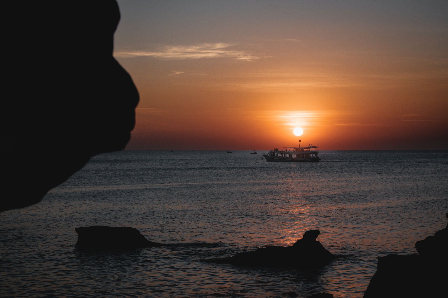 Captivating sunset scene with a boat's silhouette in Phu Quoc, Vietnam's serene ocean.