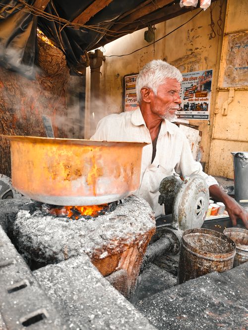 Free Elderly man cooking traditionally outdoors in Nandurbar, India. Stock Photo
