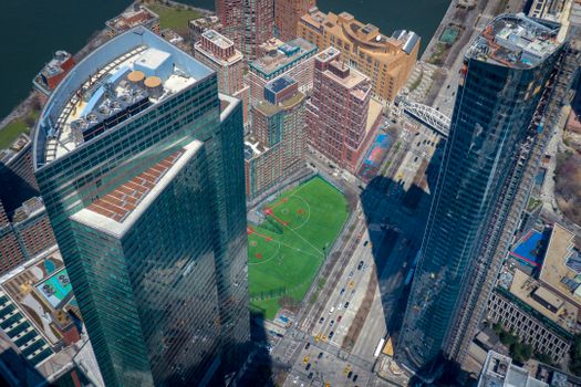 Drone shot capturing skyscrapers and baseball field in New York City, illustrating urban architecture and sports facilities from above.