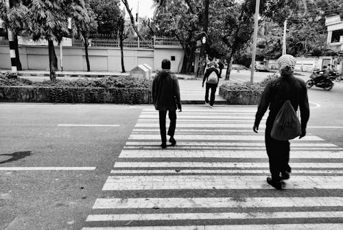 Grayscale Photo of People Walking on Pedestrian Lane