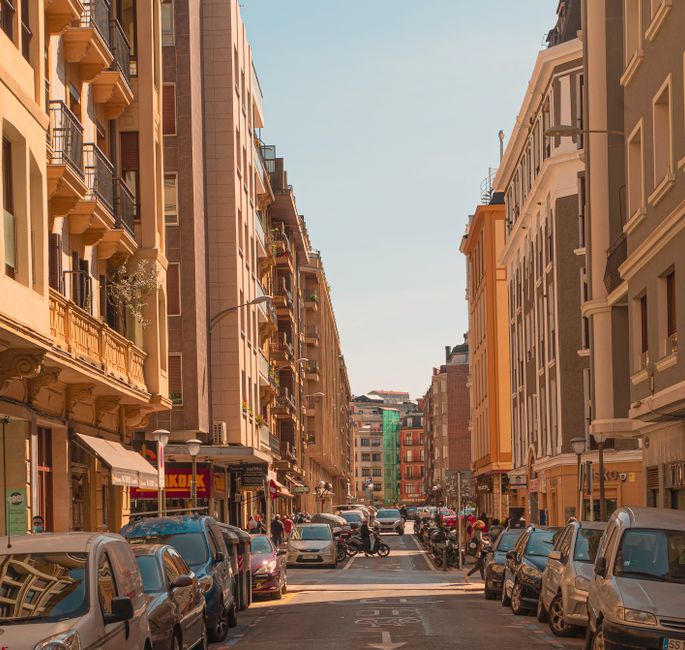 Una vibrante escena de calle urbana con actividad bulliciosa y arquitectura europea clásica.