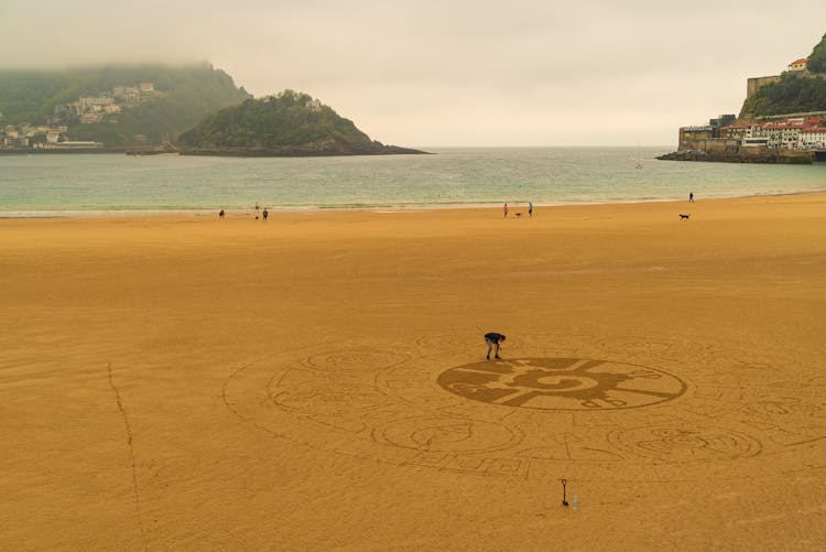 Aerial View Man Drawing In Sand On The Coast In San Sebastian, Spain 