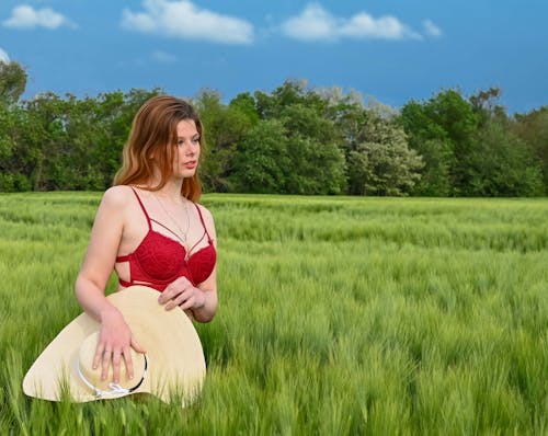 Woman in Red Brassiere Holding a Sun Hat