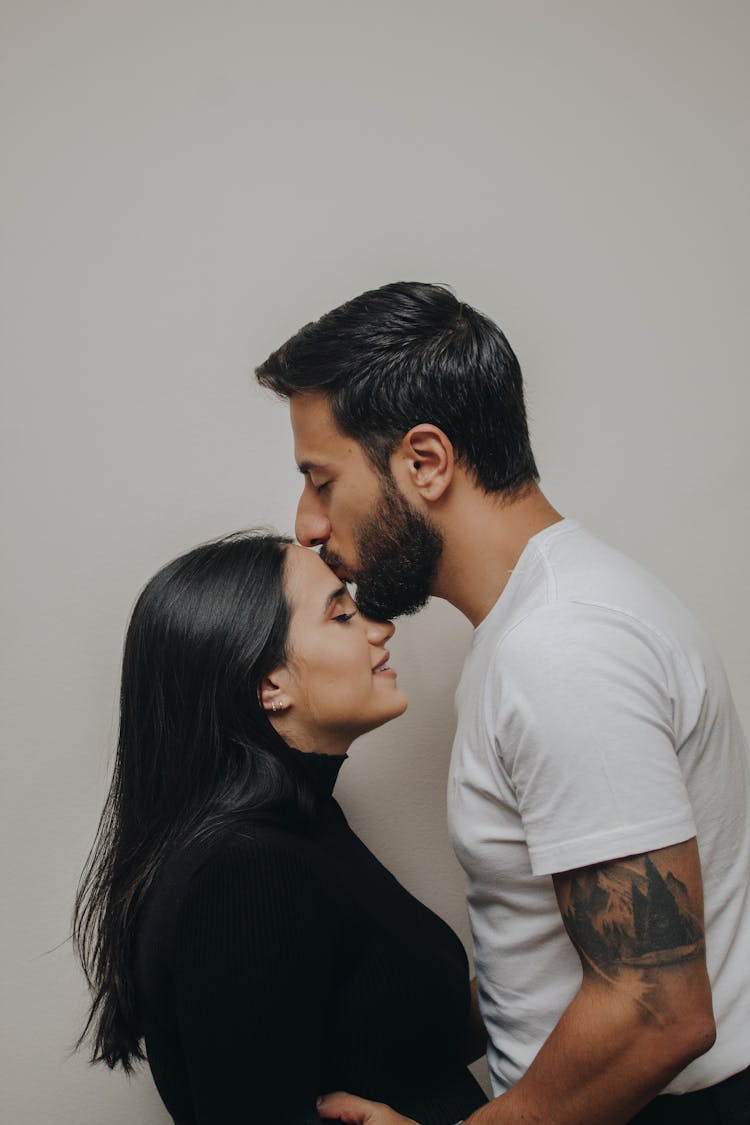 Man Kissing Woman On Forehead