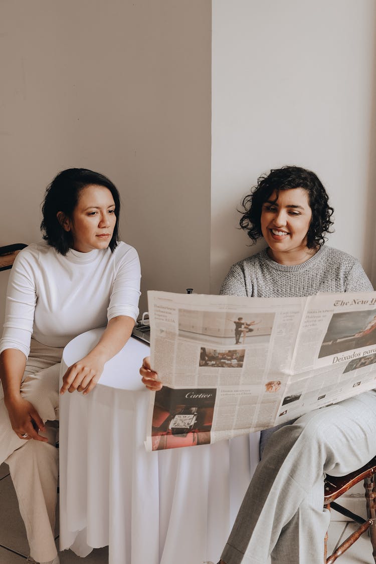 Two Women Reading Newspaper Together