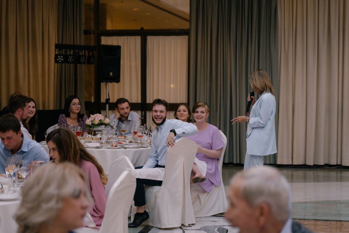 Invitado riendo espontáneamente en una mesa durante la recepción de una boda