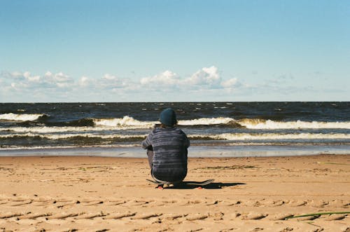 Free Person in Sand Looking over Ocean Waves Stock Photo