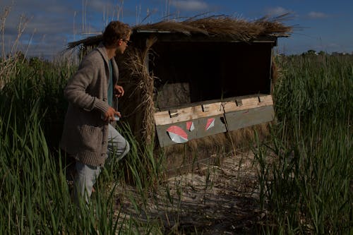 Man on a Field Next to a Hay Hut 